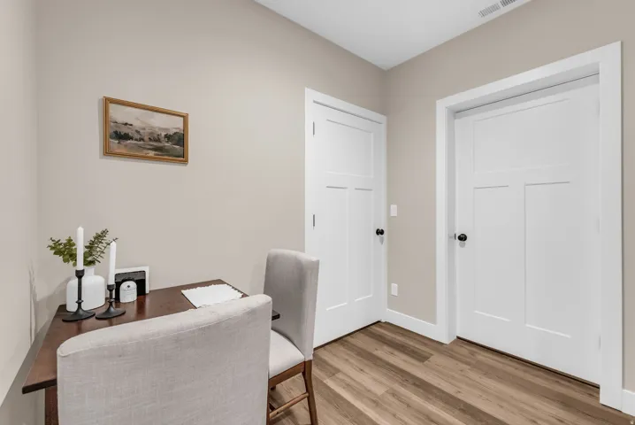 Basement kitchen wood-finish flooring, light-toned walls, and white trim