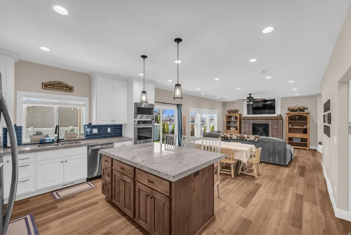 Gourmet kitchen with white cabinetry, stainless steel appliances, and a central island with a contrasting wood base
