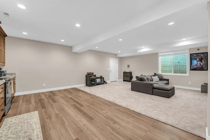 Basement ADU with Recessed lighting, wood-finish flooring, light-toned carpeting, and a window with horizontal blinds