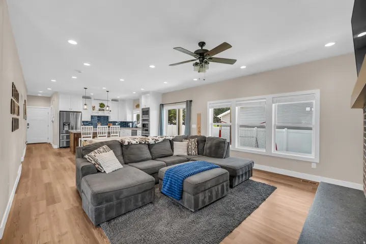 Open-concept living space featuring wood-finish flooring, recessed lighting, and a ceiling fan