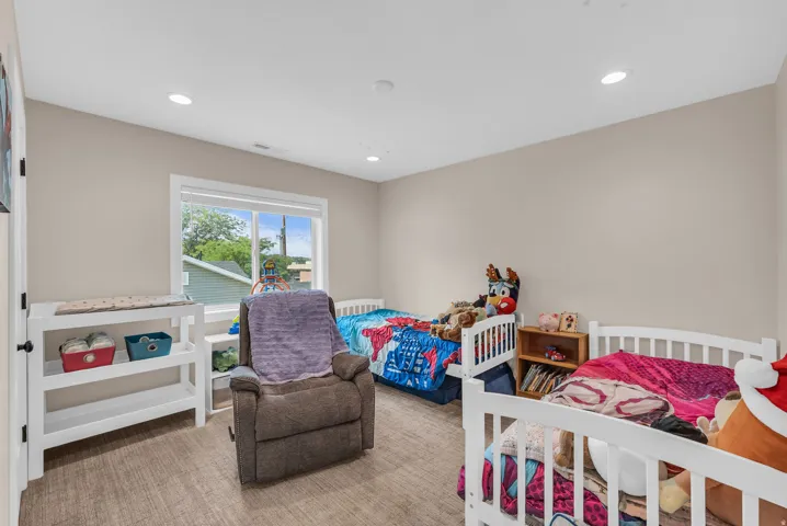 Recessed lighting, neutral wall paint, and a large window with white trim