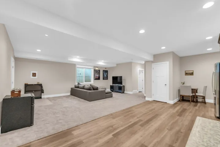Spacious multi-purpose room featuring wood-finish flooring, recessed lighting, and neutral wall tones