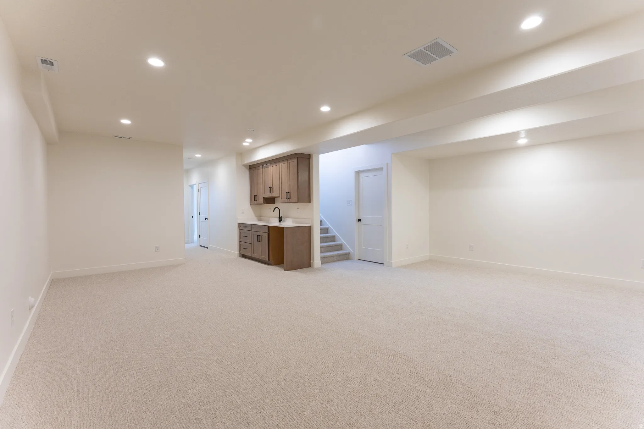Spacious lower level featuring light-toned carpeting and recessed ceiling lighting throughout