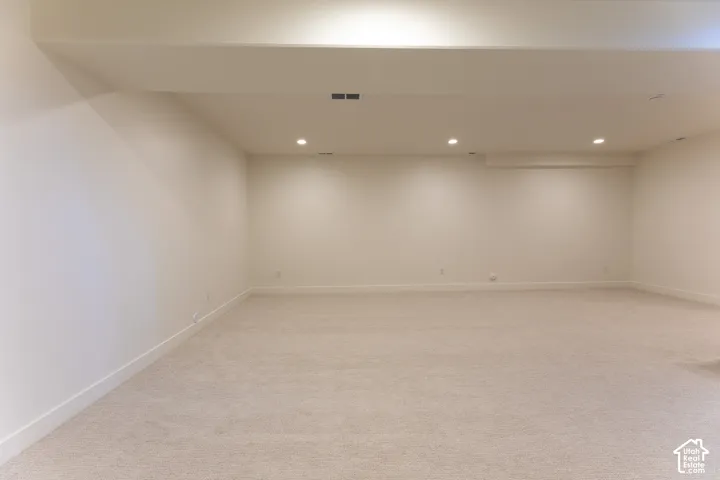 Expansive carpeted room featuring recessed lighting, light-toned walls, and white baseboards