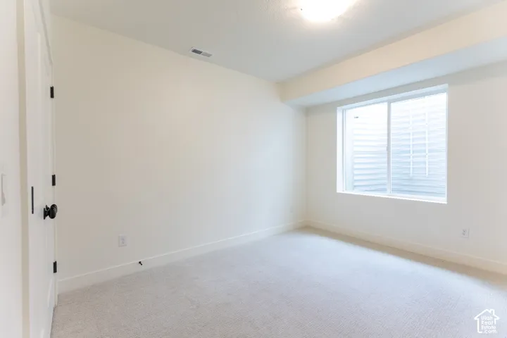 Light-colored wall-to-wall carpeting complements the neutral wall color