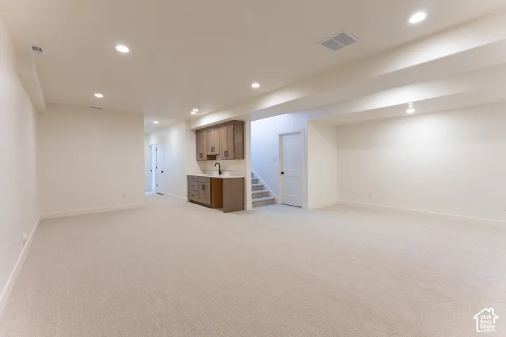 Spacious lower level featuring light-toned carpeting and recessed ceiling lighting throughout