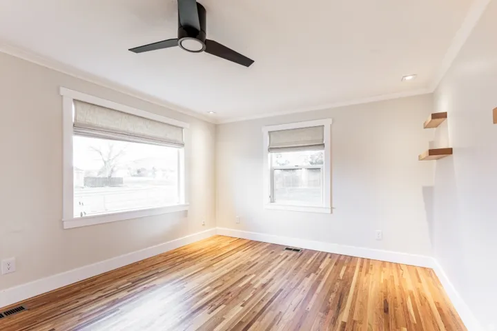 Hardwood flooring, recessed ceiling lighting, a contemporary ceiling fan, and built-in floating shelves