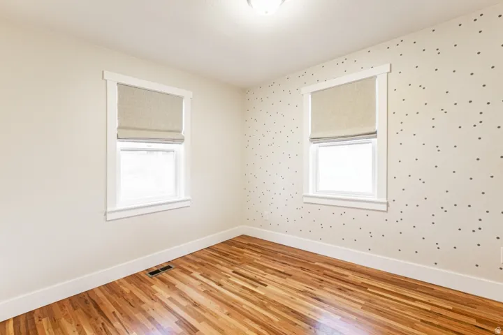 Hardwood flooring, two windows with blinds, and recessed lighting