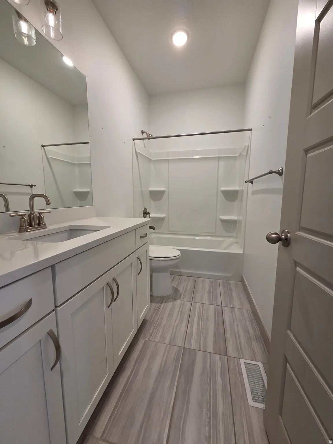 Modern vanity with a rectangular basin, brushed nickel faucet, and white shaker-style cabinetry