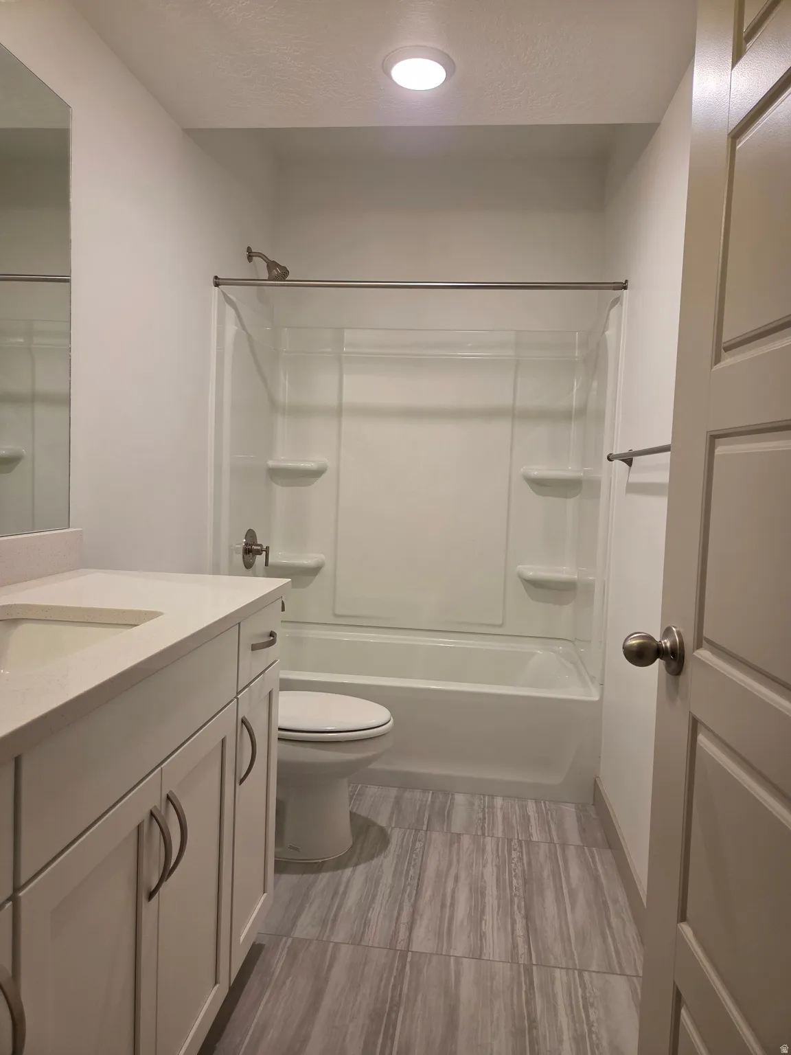 White vanity with an integrated sink, polished chrome hardware, and a solid surface countertop