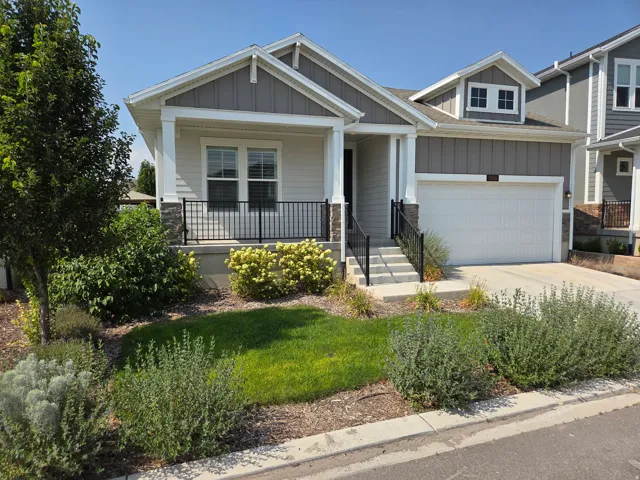 Exterior featuring a covered porch, stone accents, and a single-car garage