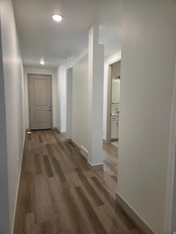 Wood-finish flooring, recessed lighting, and a paneled entry door