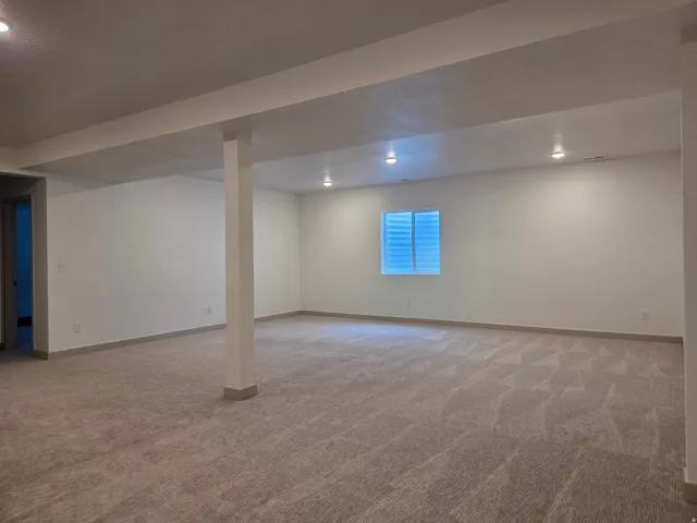 Expansive room featuring recessed lighting, a window with horizontal blinds, and patterned carpeting