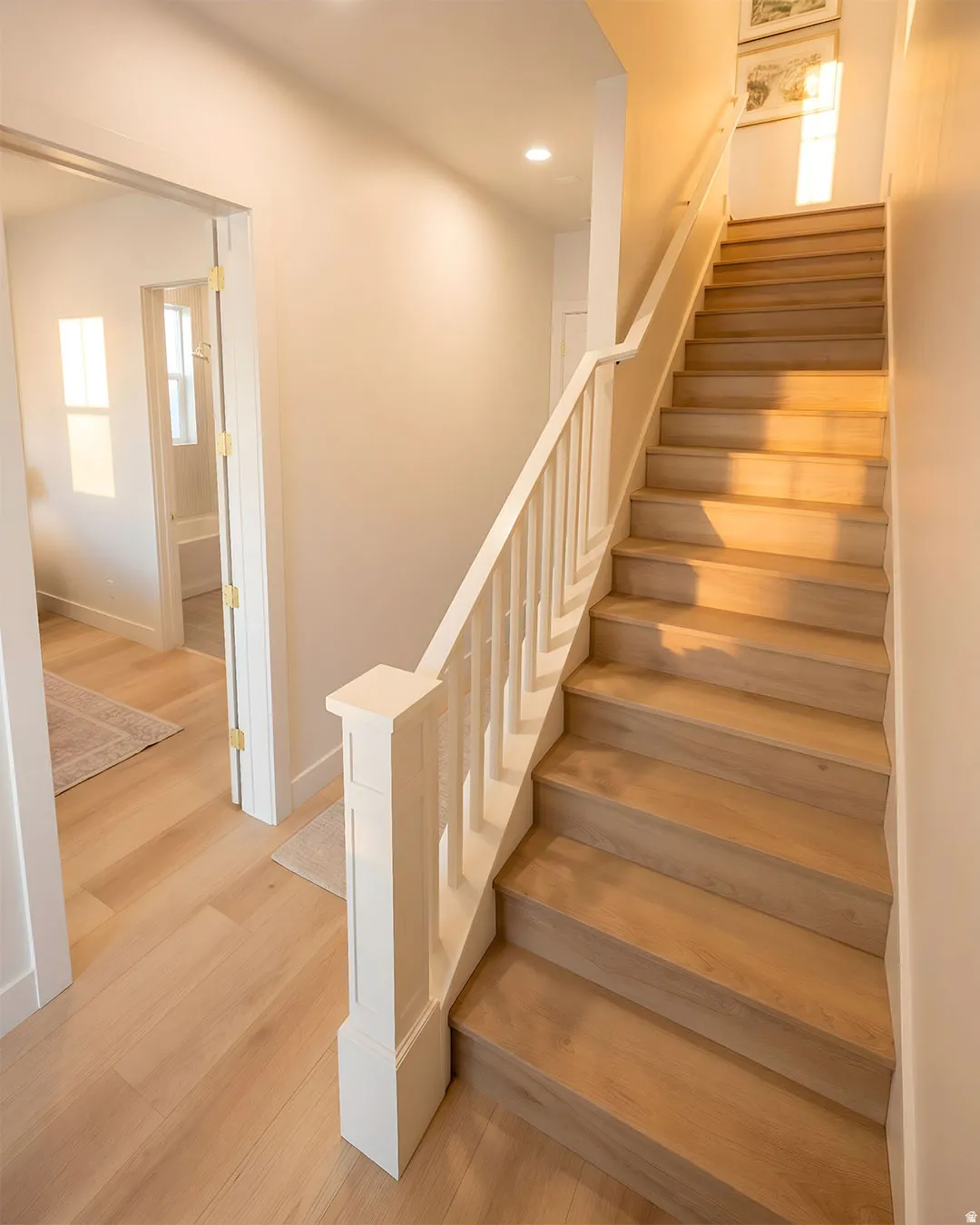 Hardwood staircase with white balusters and newel post