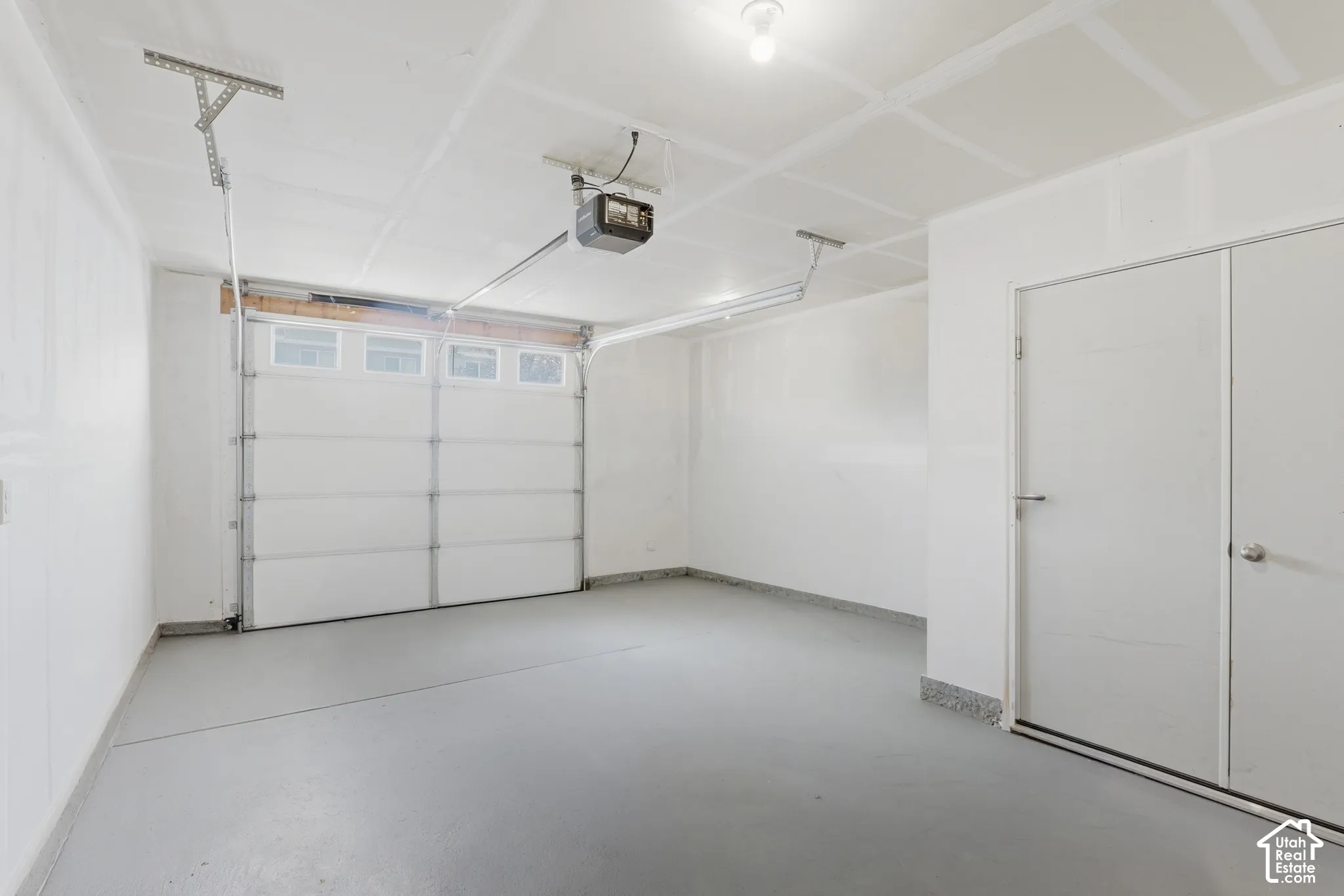 Garage with a sectional overhead door, translucent panels, and a garage door opener system