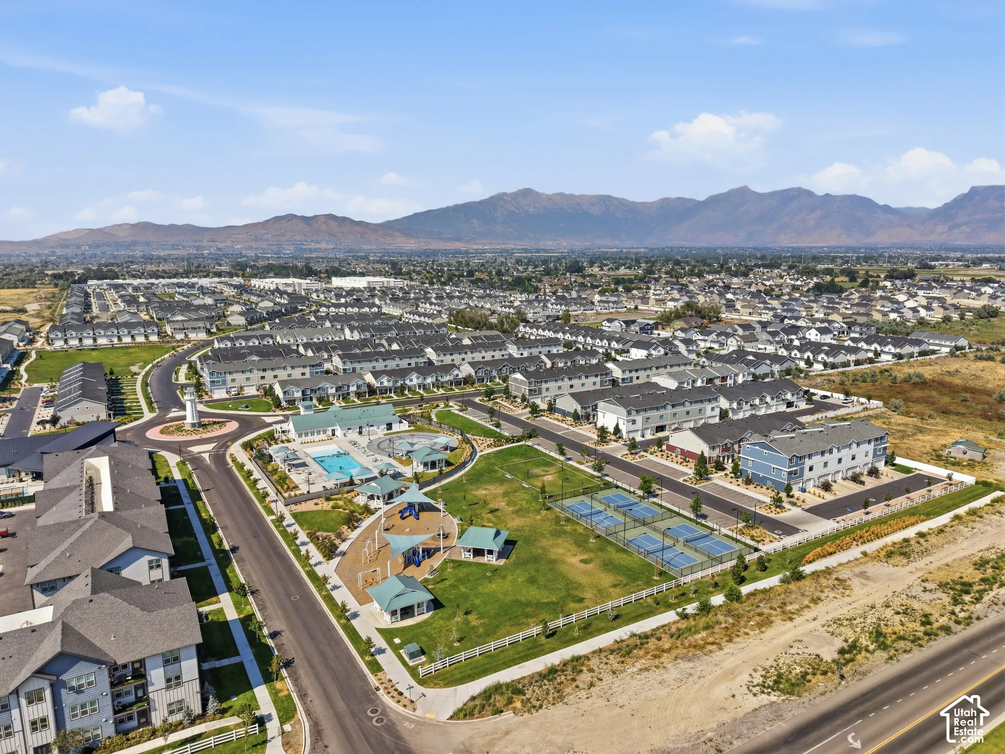 Residential community featuring multiple buildings, an outdoor swimming pool, a children's playground, and tennis courts