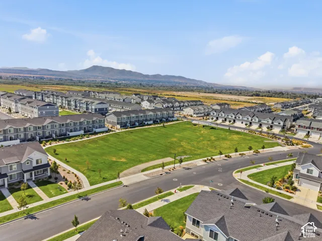 Developed community featuring multiple residential structures, paved roads, and a central green space