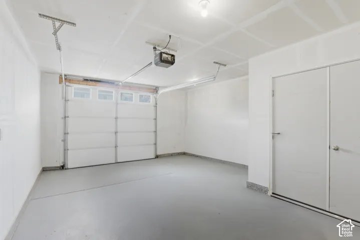 Garage with a sectional overhead door, translucent panels, and a garage door opener system