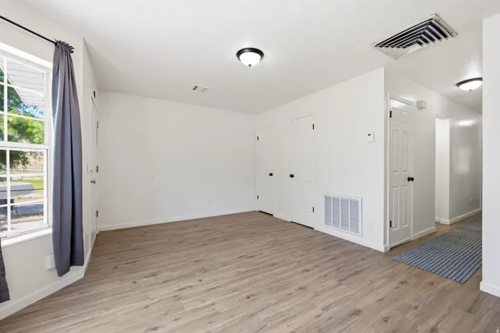 Wood-finish flooring, white walls, multiple windows, recessed lighting, and white interior doors