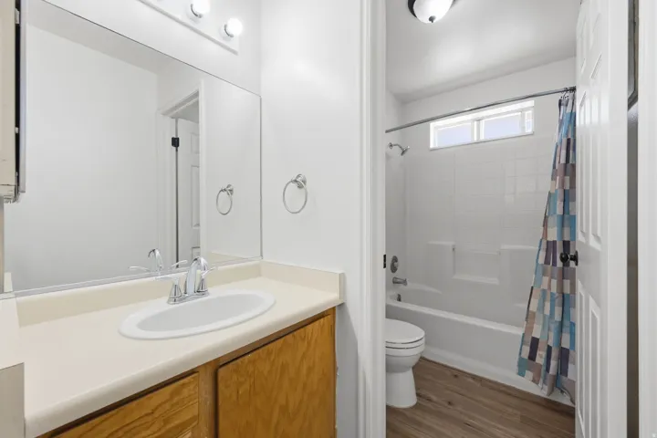 Vanity with integrated sink, chrome faucet, and wood-finish cabinetry