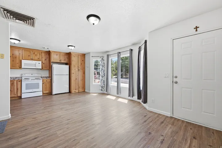 Open-concept living area with wood-finish flooring, recessed lighting, and bay windows