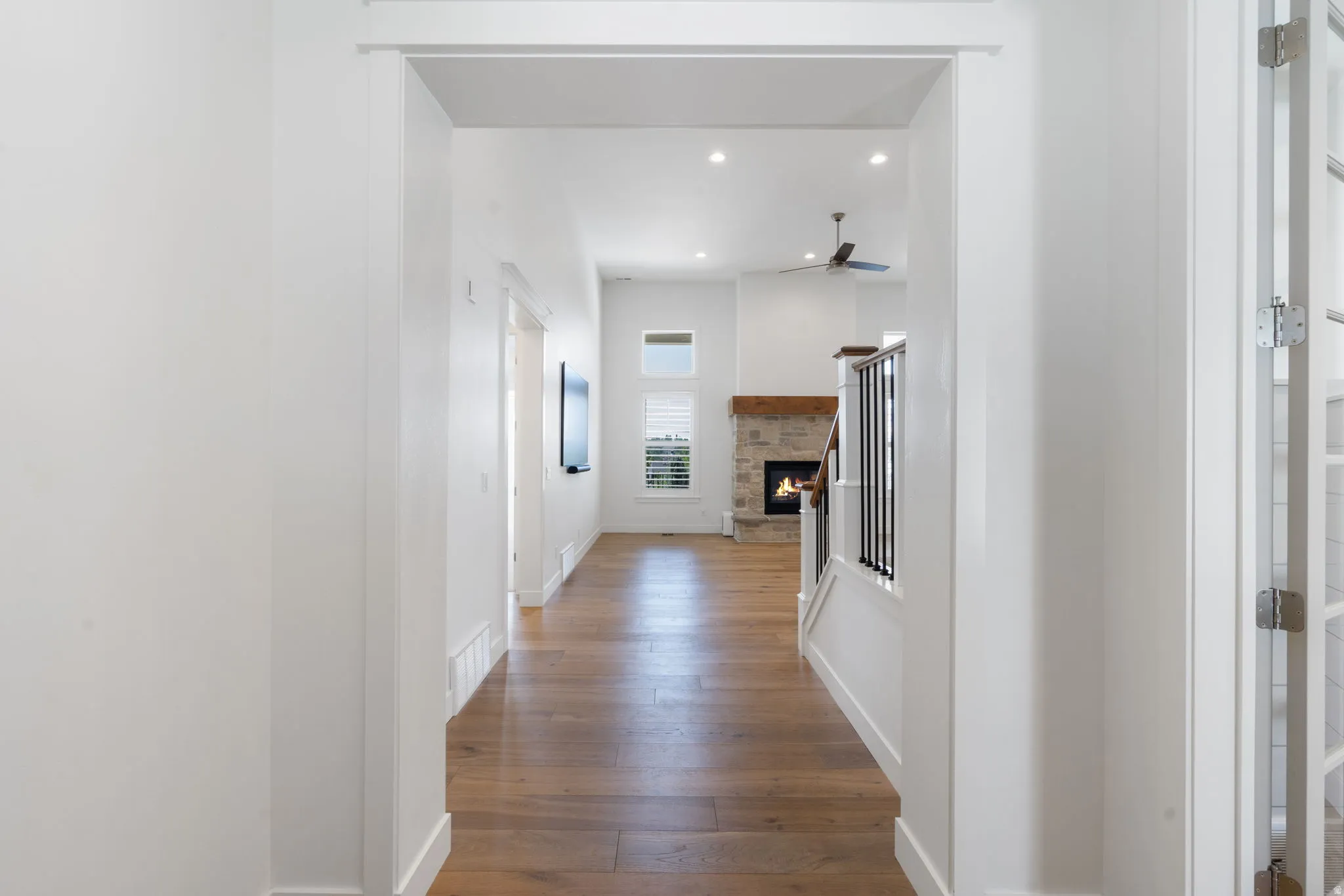 Wood-finish flooring throughout, with recessed lighting and a ceiling fan