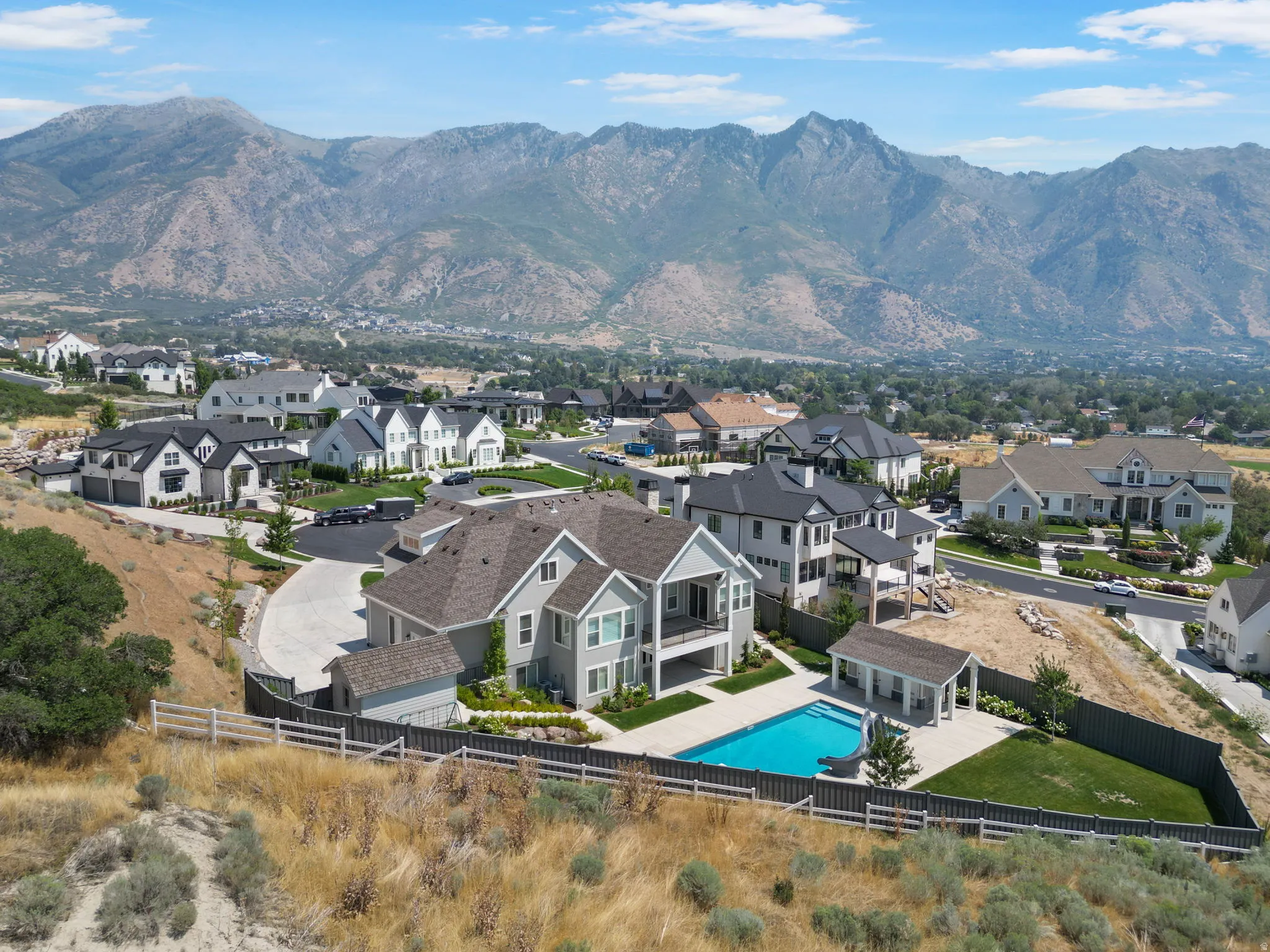 Exterior featuring a private pool, pool house, and an expansive mountain backdrop