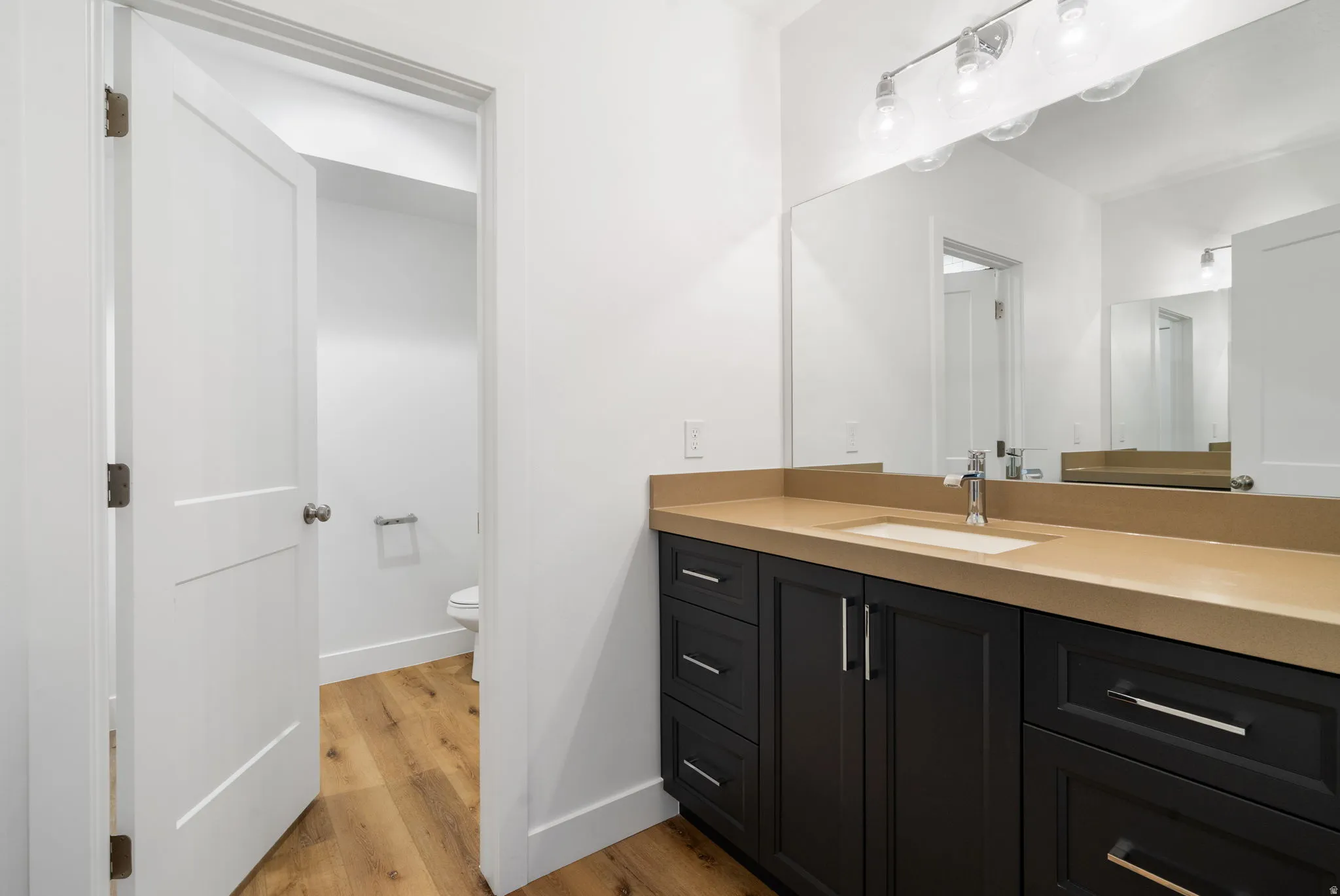 Vanity with a neutral-toned countertop and an integrated rectangular sink