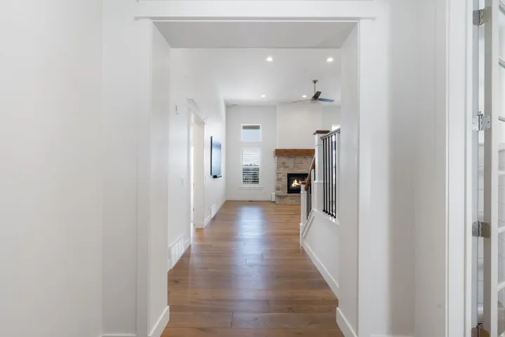 Wood-finish flooring throughout, with recessed lighting and a ceiling fan