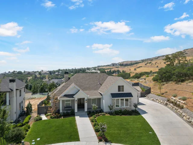 Modern residence featuring a clean architectural design with a peaked roofline, composite or asphalt shingle roof, and light-colored exterior siding