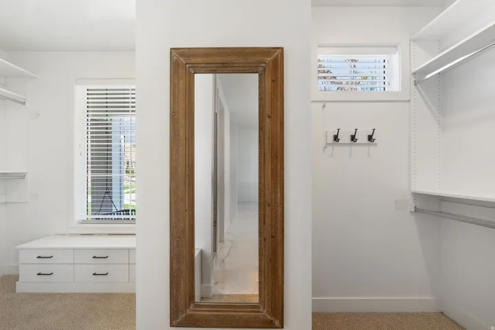 Built-in shelving, built-in drawer storage, and a full-length mirror