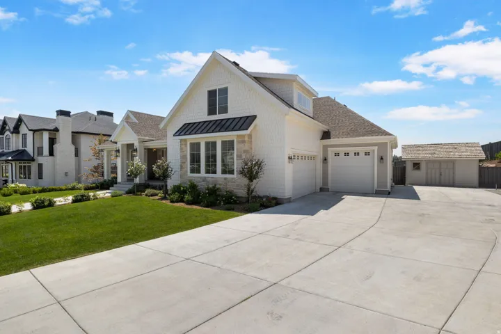White shingle siding with stone accents and a covered entry