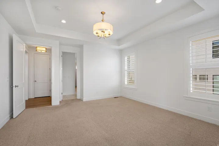 Tray ceiling with recessed lighting and a central chandelier
