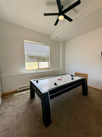 Recessed lighting, sloped ceiling, window with blinds, ceiling fan, and carpeted flooring