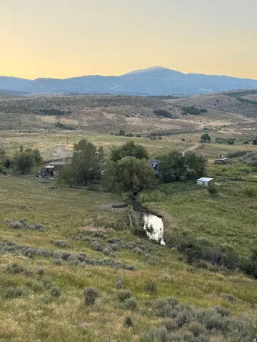 Backyard view featuring creek, rolling hills and distant mountains to the west with lake views to the east