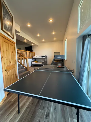 Recreation room featuring wood-finish flooring, recessed lighting, and a prominent sliding glass door