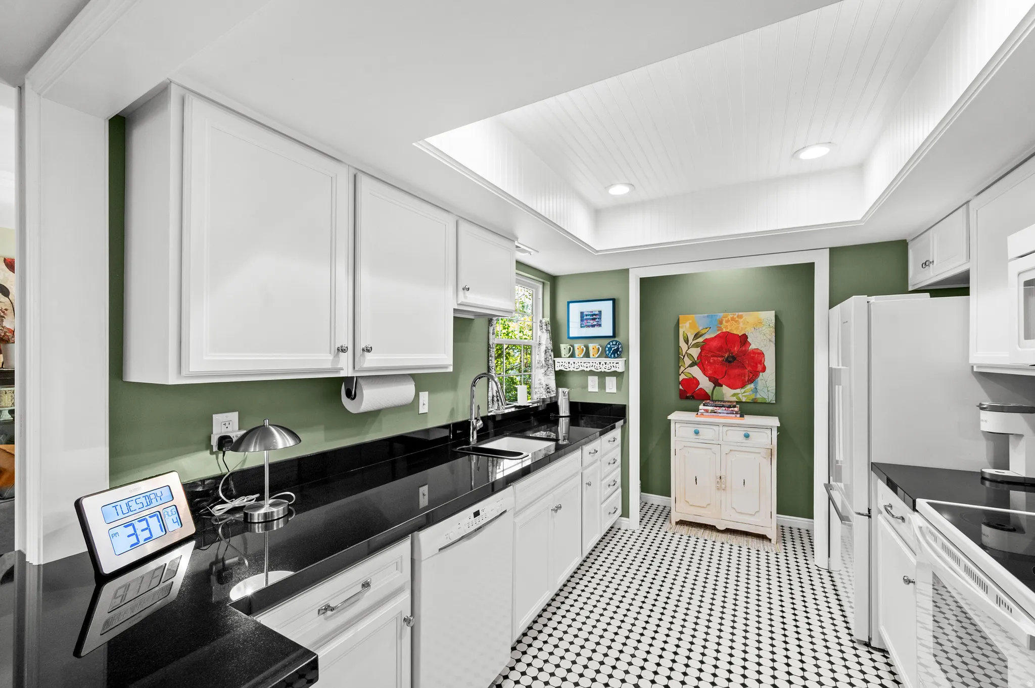 Kitchen featuring white cabinetry, black countertops, a drop ceiling with recessed lighting, and a black and white hex tile floor