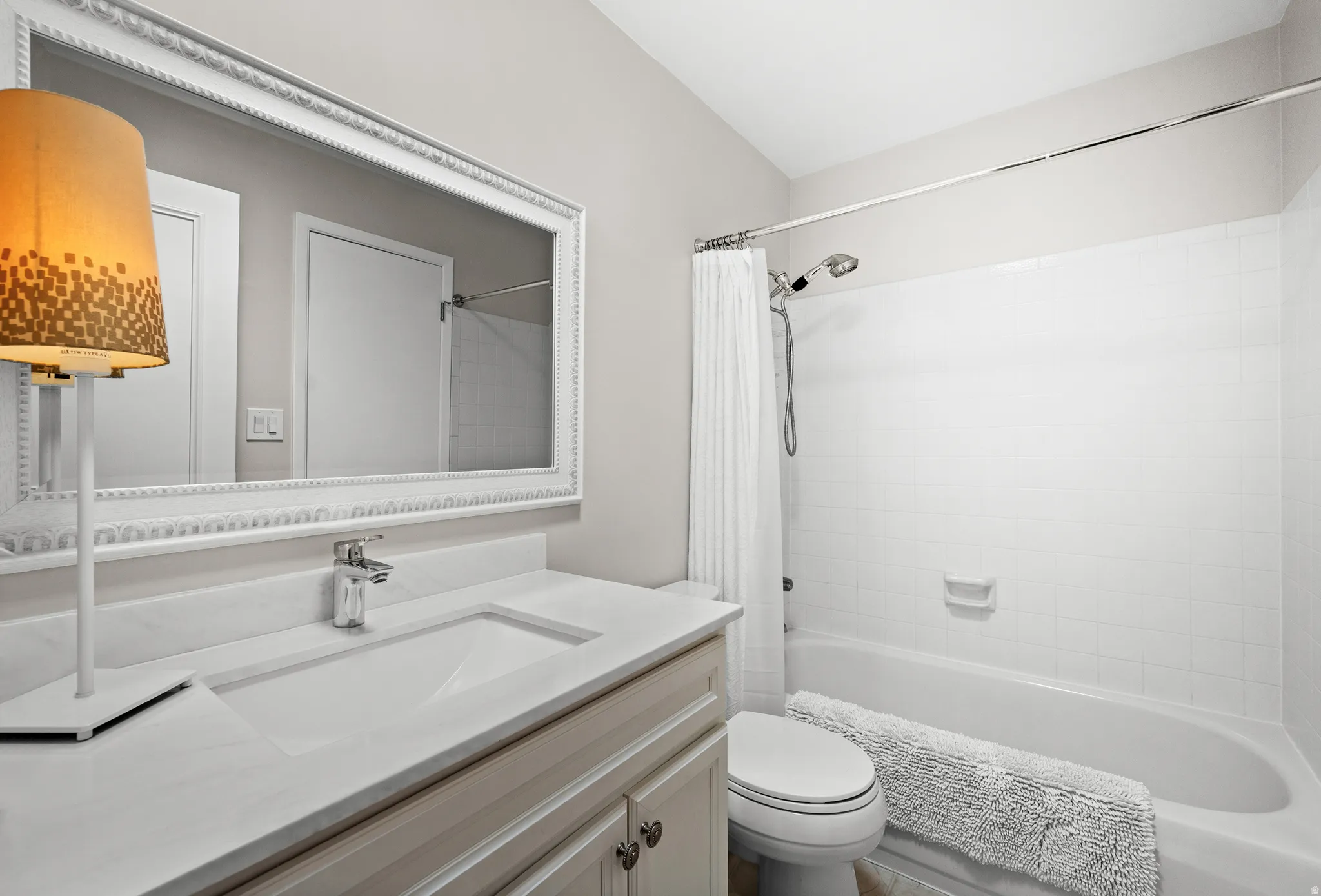 Vanity with integrated sink, chrome faucet, and white countertop