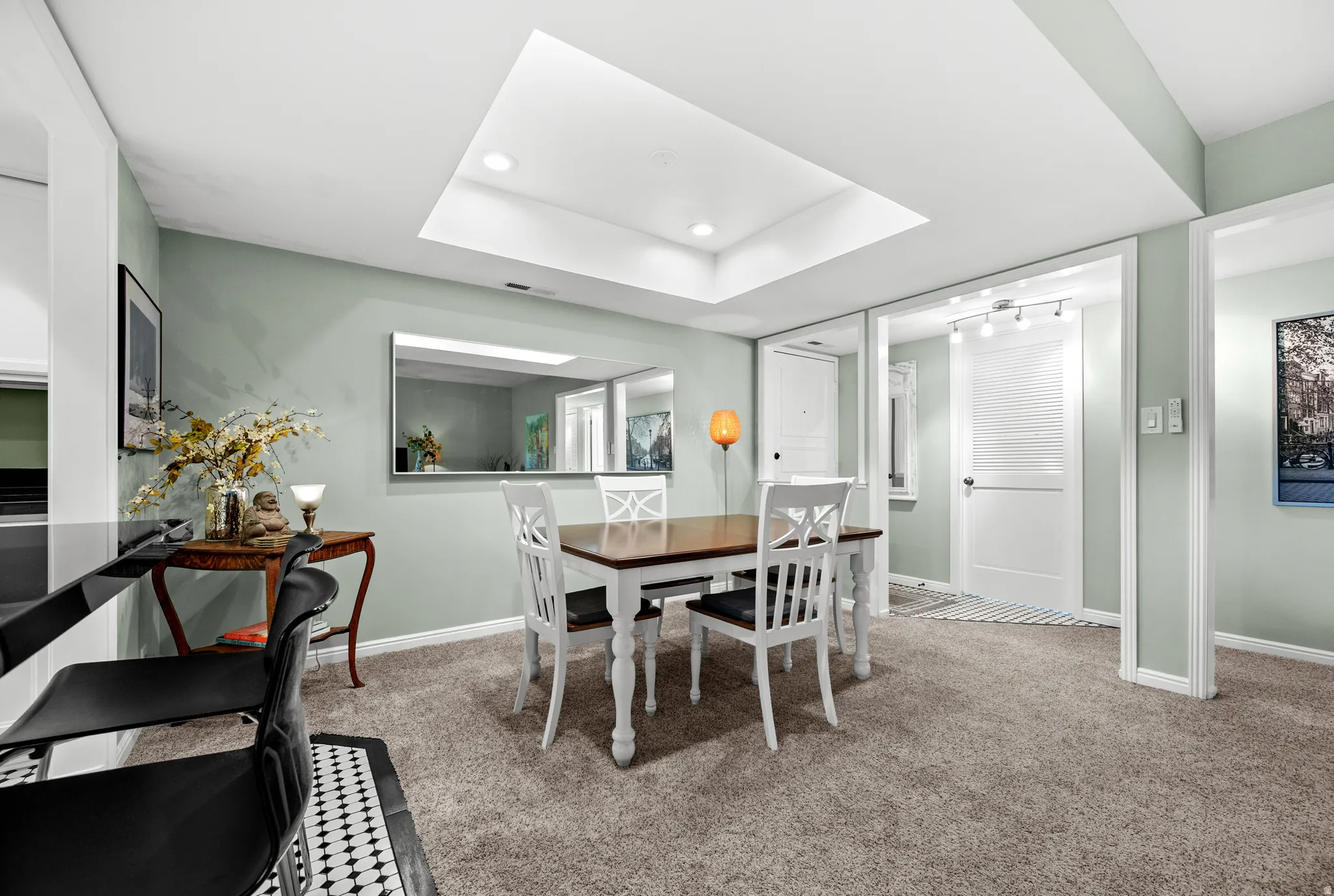 Recessed lighting, skylight feature, wall-mounted mirror, light-colored carpeting, and painted interior walls