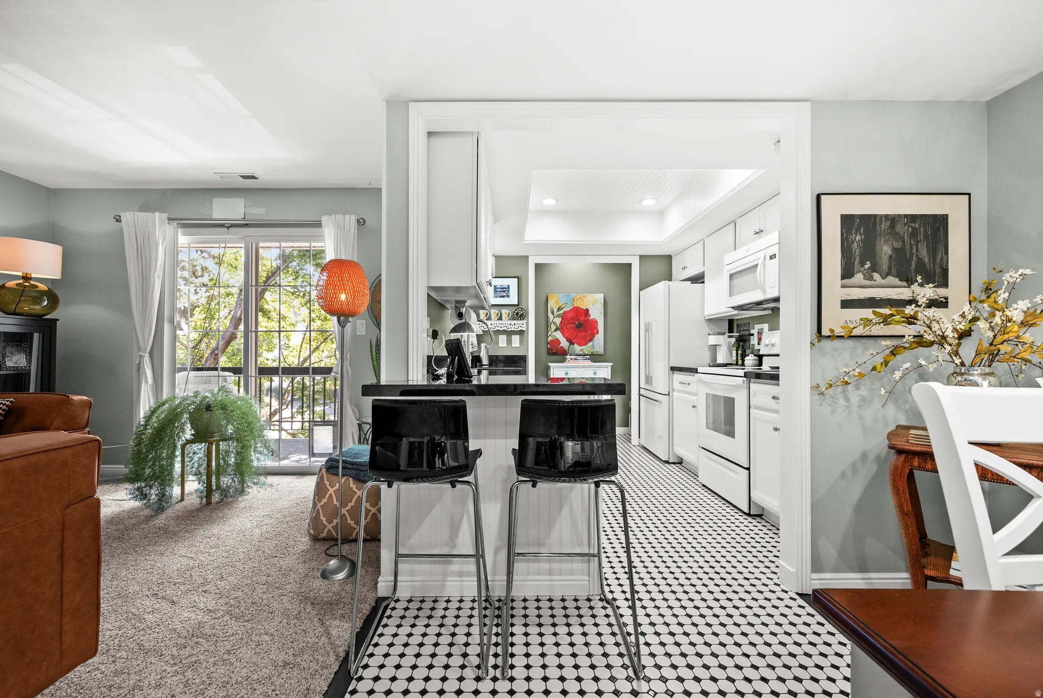 Kitchen with white appliances, black and white mosaic flooring, and recessed lighting