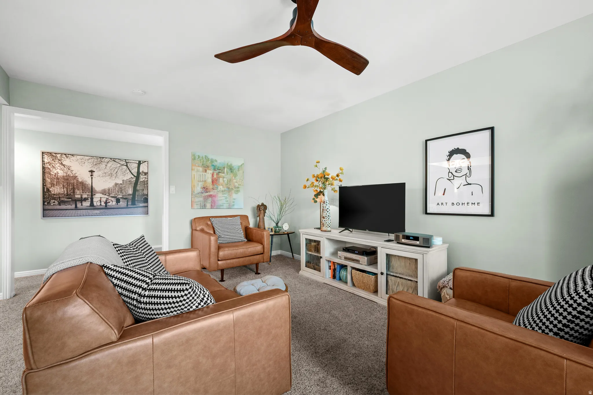 Spacious room with light-toned walls, a built-in ceiling fan, and plush carpet flooring