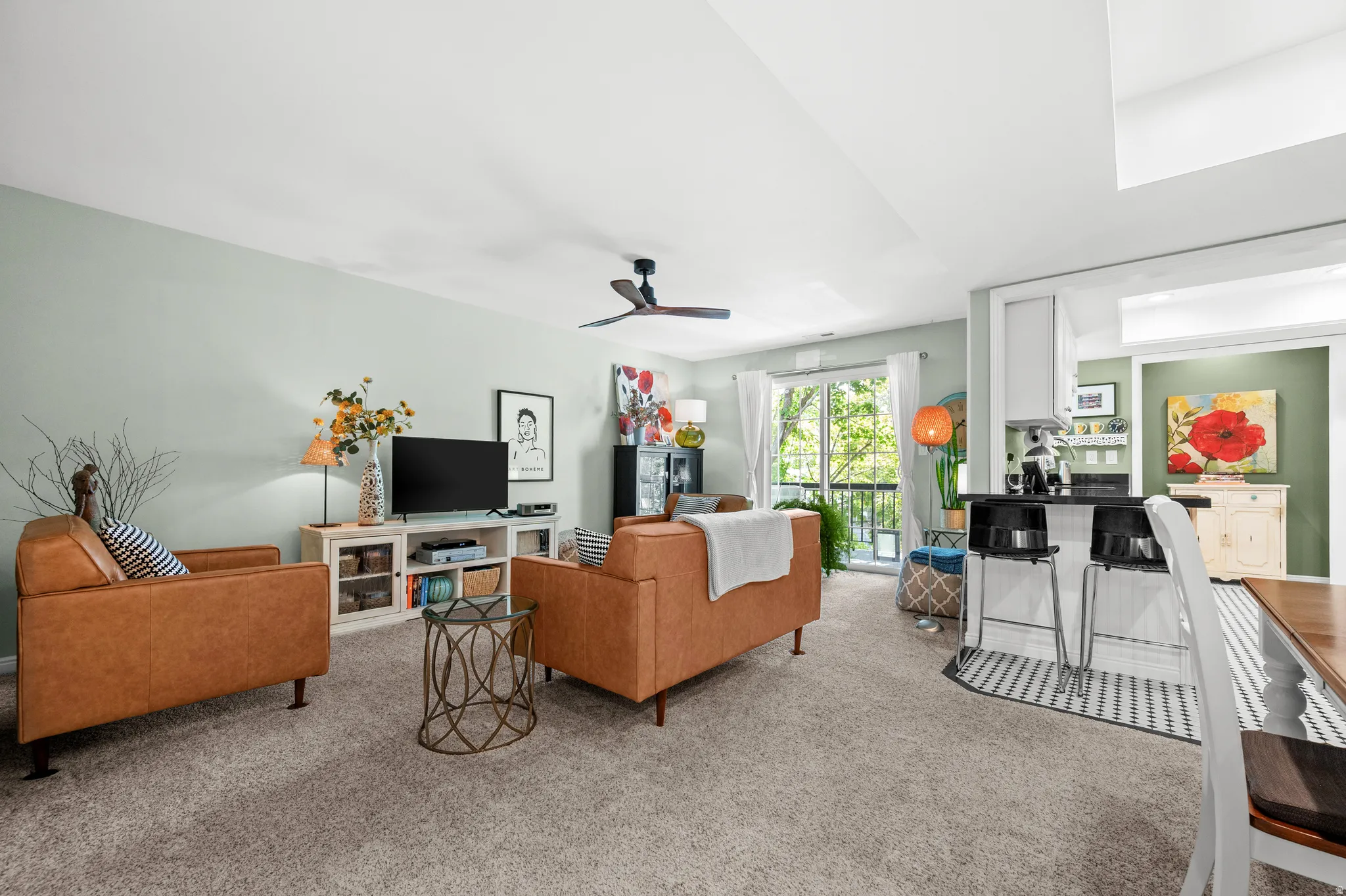 Open-concept living area featuring light-colored walls and a ceiling fan