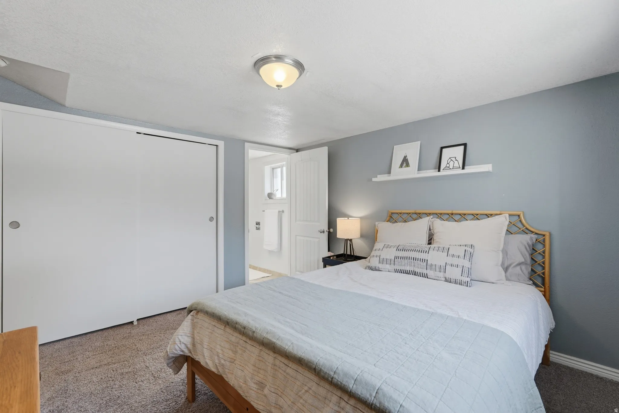 Recessed lighting, light-colored carpeting, built-in shelving, white sliding closet doors, and an en-suite bathroom access