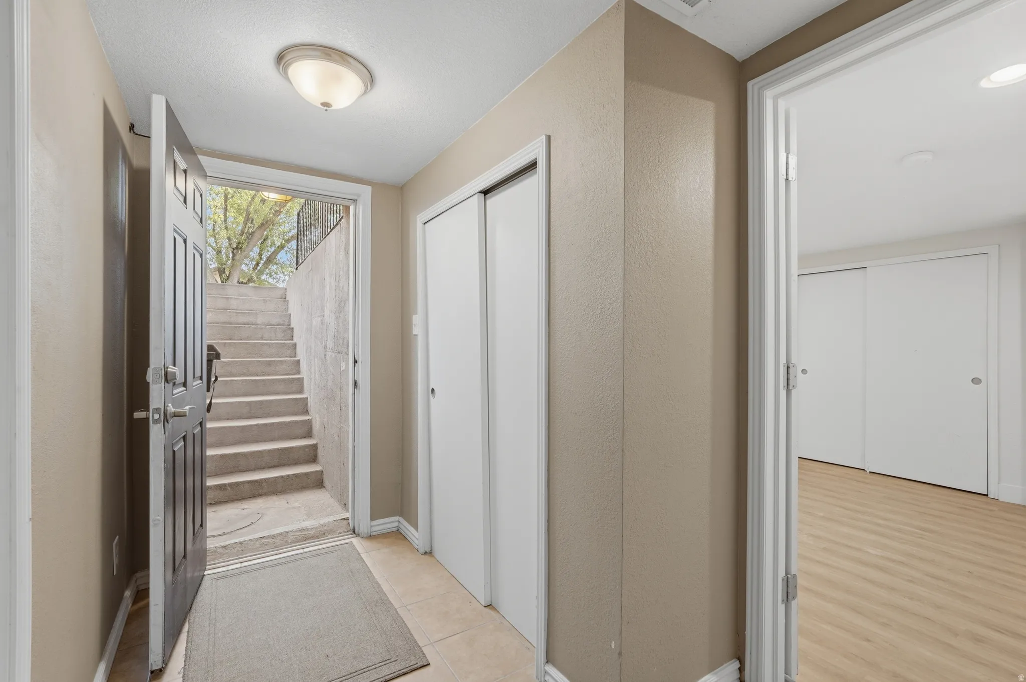 Bright hallway featuring neutral wall finishes, recessed ceiling lighting, wood-finish flooring, and multiple white panel doors providing access to adjoining spaces