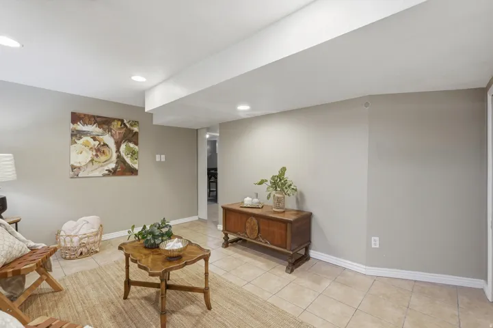 Spacious recreation room featuring neutral wall finishes, recessed ceiling lighting, and tile flooring throughout