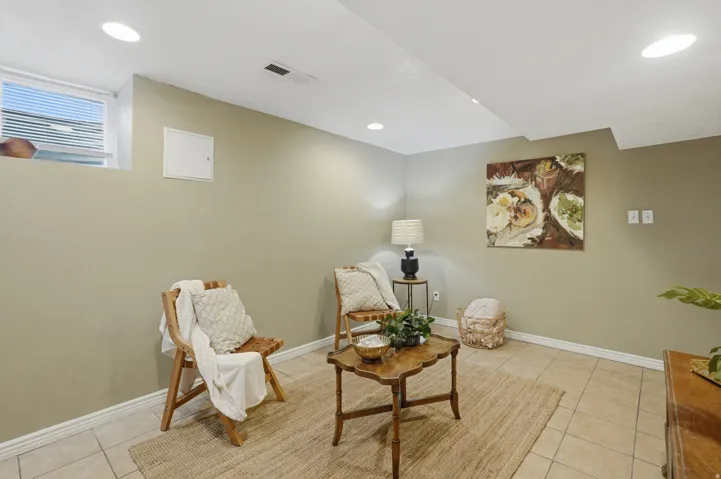 Recessed ceiling lighting illuminates the space, featuring a window with integrated blinds
