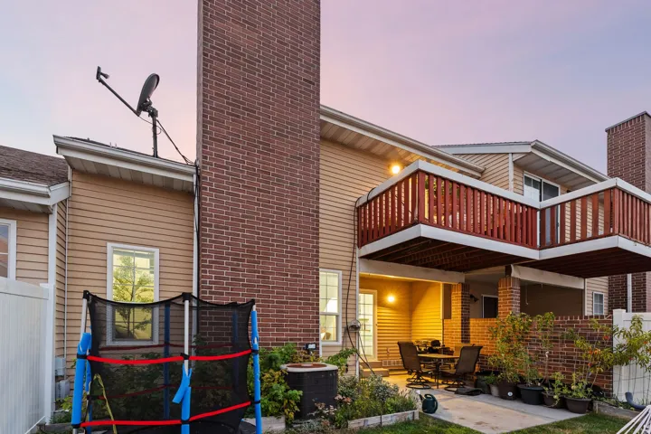 Two-story exterior with horizontal siding and a prominent brick chimney