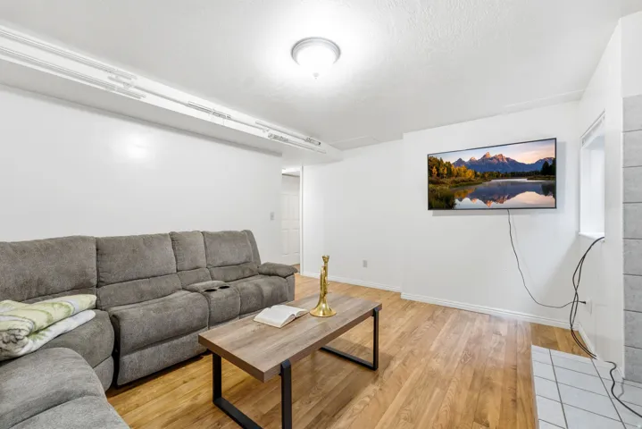 Wood-finish flooring, recessed ceiling lighting, and a white tile hearth