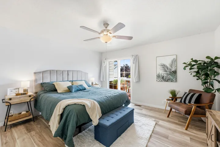 Wood-finish flooring, ceiling fan, sliding glass door, and neutral wall tones