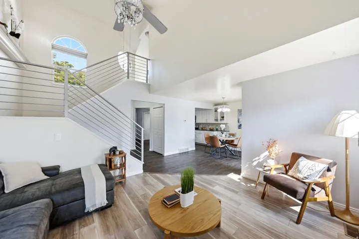 Vaulted ceilings, wood-finish flooring, and an open-tread staircase with metal railing